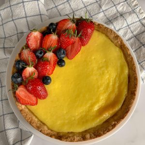 A vibrant fruit tart with fresh strawberries and blueberries on a baked crust.