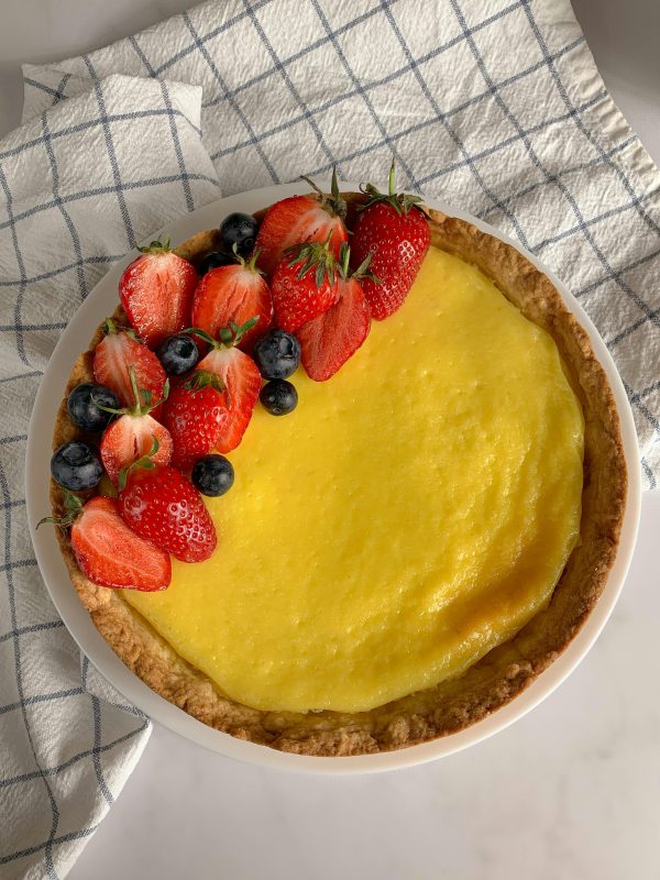 A vibrant fruit tart with fresh strawberries and blueberries on a baked crust.